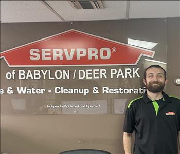 photo of employee in front of SERVPRO franchise sign