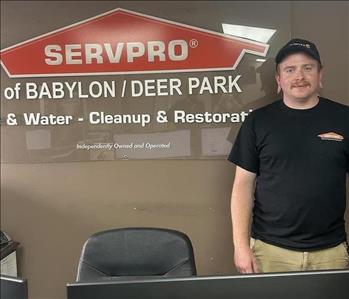 photo of employee in front of SERVPRO franchise sign